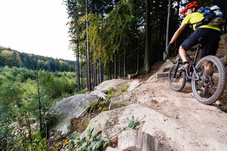 mountain-biker-riding-cycling-in-autumn-forest-P7KGPCL